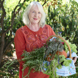 Portrait of a gardener carrying a basket full of plants.