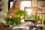 Woman using the Click & Grow 25 indoor gardening system.