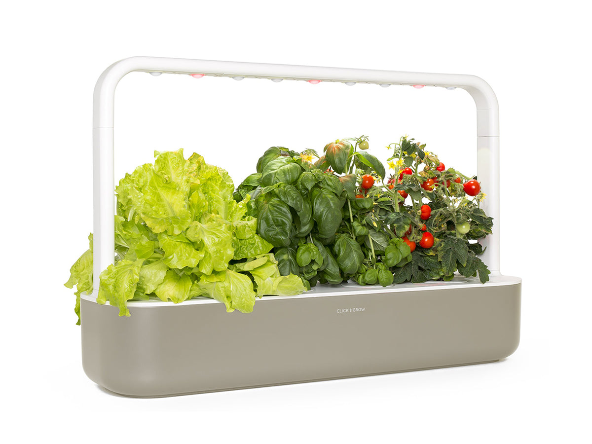 The Smart Garden 9 / A close up side view of The Smart Garden 9 by Click and Grow in a beige container.